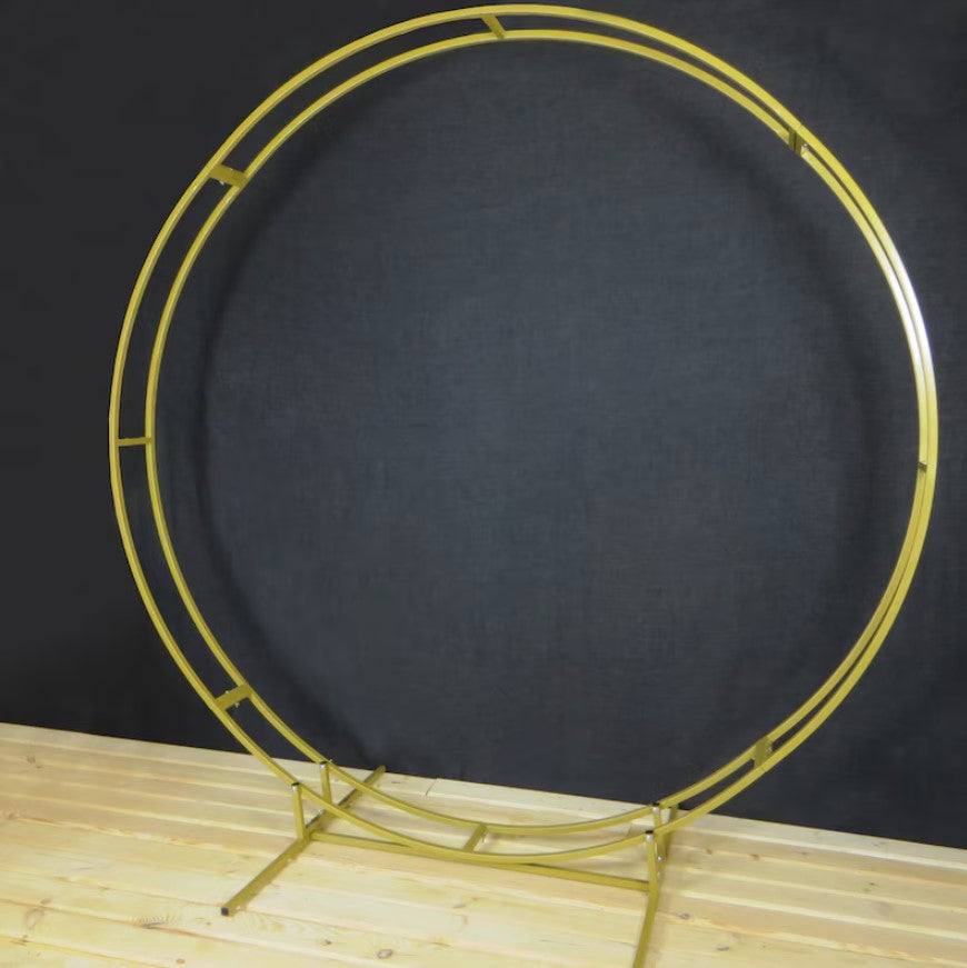 Gold circular metal stand on a wooden surface with a dark background