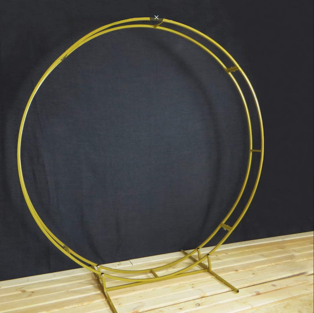 Gold circular metal stand on a wooden surface with a dark background