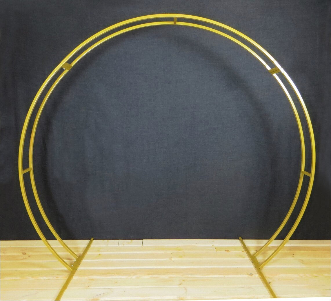 Gold circular metal arch on a wooden surface with a dark gray background